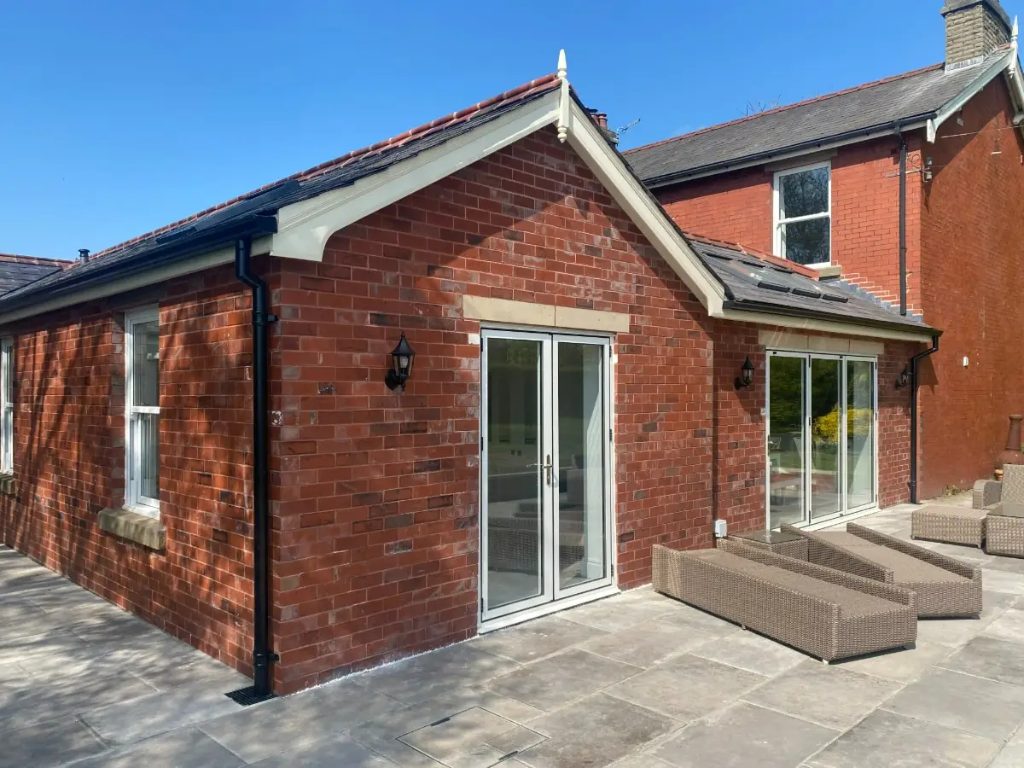 Completed brick extension with patio and white joinery