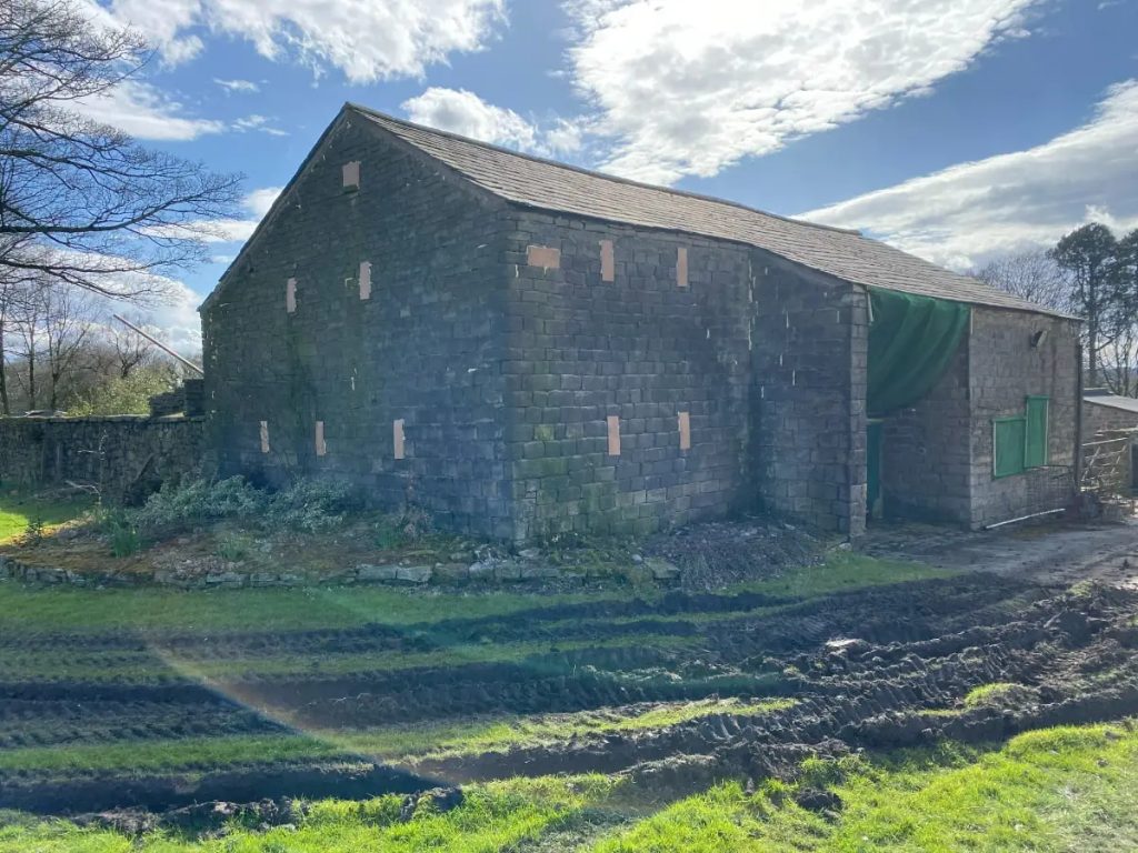 Stone barn with slate roof on a rural site
