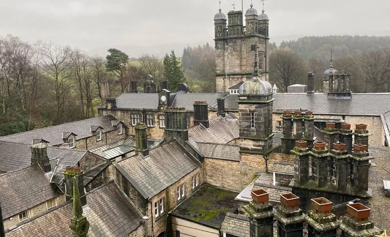 Roofline of a historic stone school building with slate roofs and towers